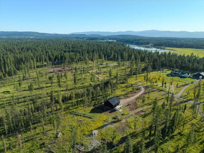 Aerial overview of property's location with a heavily wooded area and a water and mountain view | Image 72