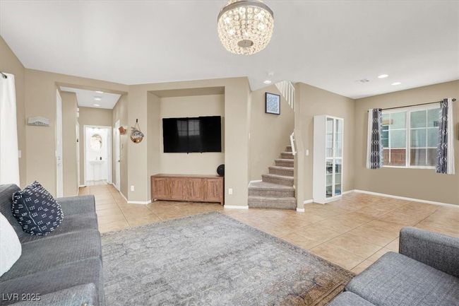 Living area featuring light tile patterned floors, stairs, a chandelier, baseboards, and recessed lighting | Image 6