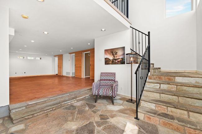 Ground level entry from the side of the house, opening to the large flex space and flagstone stairs leading up to the main level. | Image 22