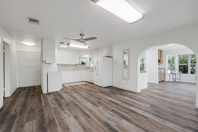Upon entry, you are welcomed into an open concept updated with vinyl plank flooring. The Primary Bedroom is to the right of the front door. | Image 5