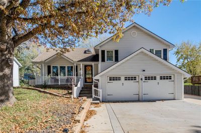 View of front facade featuring a garage and a porch | Image 1