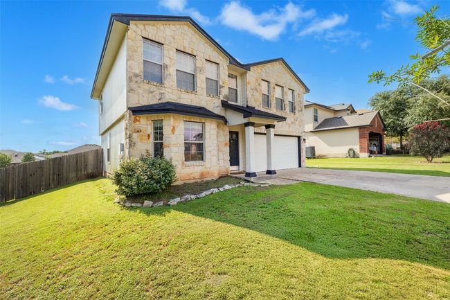 View of front of home featuring stone siding, concrete driveway, and a garage | Image 11