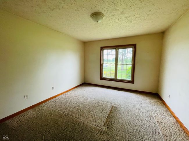 unfurnished room with light colored carpet, baseboards, and a textured ceiling | Image 13