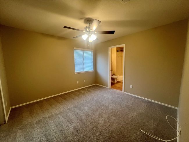 Unfurnished bedroom featuring carpet flooring, ensuite bathroom, and a ceiling fan | Image 28