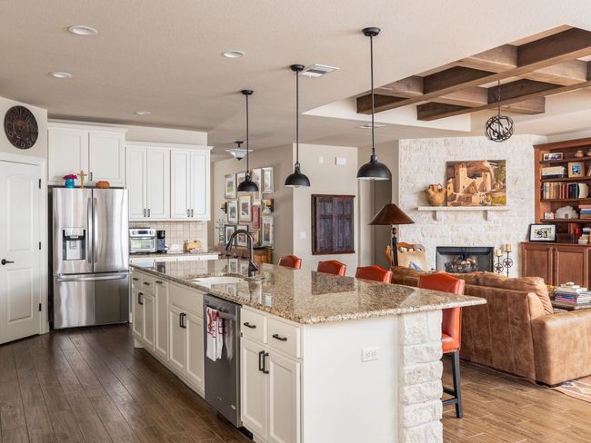 Kitchen featuring stainless steel appliances, a breakfast bar area, dark wood-style flooring, and white cabinets | Image 8