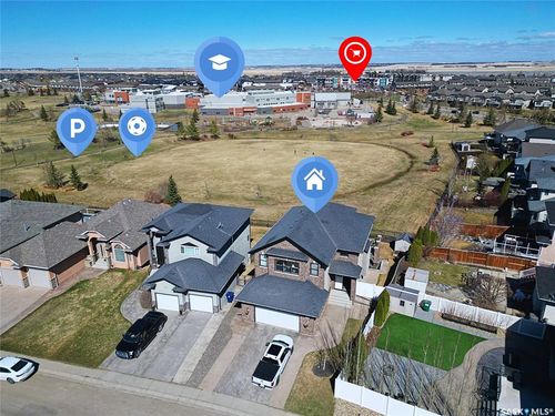 Residential property featuring a brick and siding exterior, two attached garages, and a paved driveway | Card Image