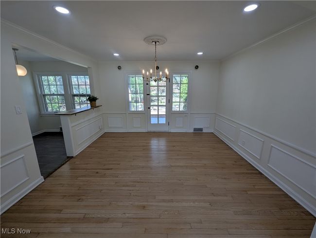 Unfurnished dining area with recessed lighting, an inviting chandelier, wood finished floors, and a decorative wall | Image 10