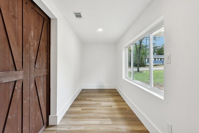 Hallway featuring light wood finished floors, visible vents, recessed lighting, and baseboards | Image 19