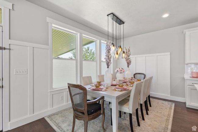 Dining area with a decorative wall, dark wood-style floors, a wainscoted wall, recessed lighting, and a chandelier | Image 7