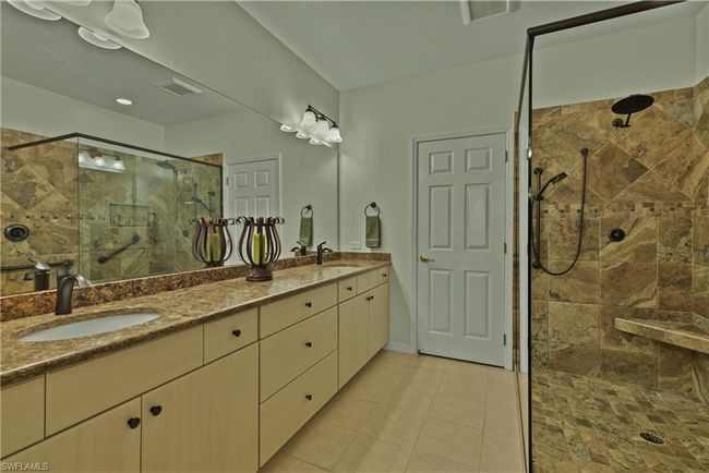 Bathroom featuring tiled shower, tile patterned floors, and vanity | Image 10