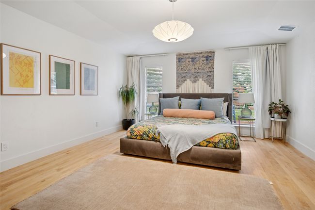 Primary bedroom overlooks scenic backyard with a walk-in closet and ensuite bathroom. | Image 12