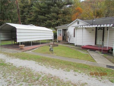 r VIEW OF THE HOUSE Showing the MAIN ENTRY to the left from Carport | Image 1