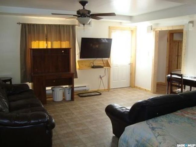 Tiled living room with ceiling fan and baseboard heating | Image 45