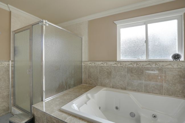Bathroom featuring a stall shower, crown molding, and a jetted tub | Image 33