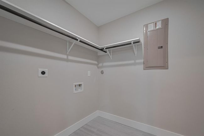 The laundry area is both functional and spacious, with room for full-size appliances and a built-in rack and overhead rod for streamlined organization. | Image 30