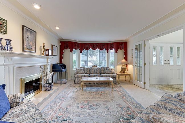 Living room with carpet, ornamental molding, and a fireplace | Image 6