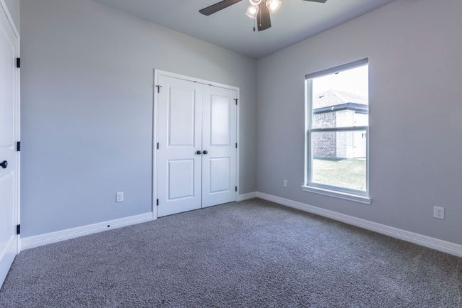 Unfurnished bedroom with carpet flooring, multiple windows, ceiling fan, and a closet | Image 17
