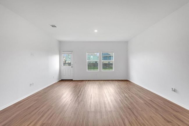 Unfurnished living room with visible vents, baseboards, and wood finished floors | Image 7