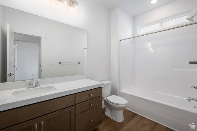Full bathroom featuring vanity, toilet, wood finished floors, and bathtub / shower combination | Image 5