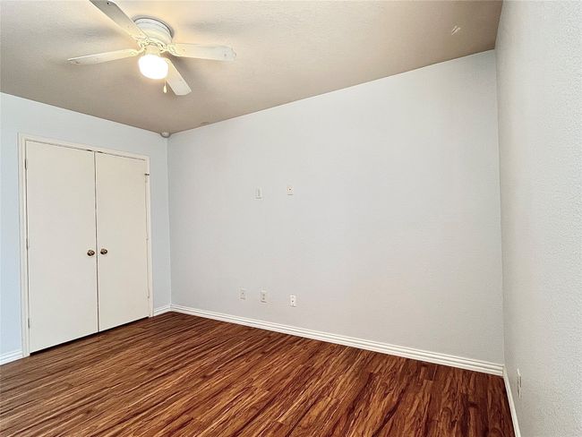 Unfurnished bedroom featuring wood finished floors, a closet, and a ceiling fan | Image 31