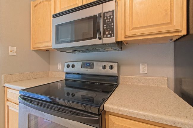 Kitchen featuring appliances with stainless steel finishes, light brown cabinetry, and light countertops | Image 22