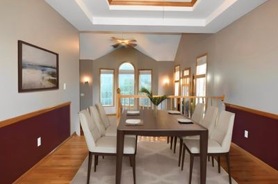 Dining area featuring ceiling fan, hardwood / wood-style flooring, and a tray ceiling | Image 3