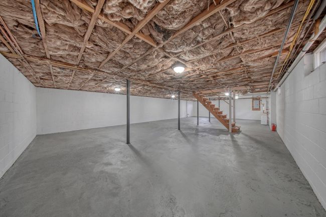 Unfinished below grade area with concrete block wall and stairway | Image 26