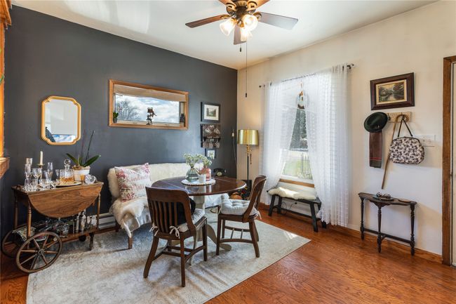 Dining area featuring ceiling fan, a baseboard radiator, wood finished floors, and baseboards | Image 7
