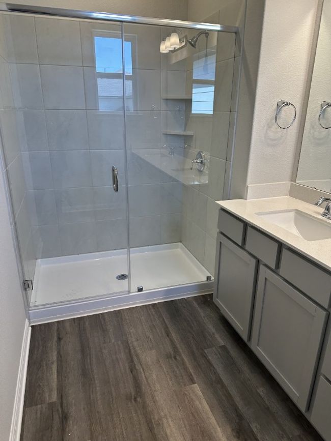 Bathroom with vanity, a stall shower, and wood finished floors | Image 12