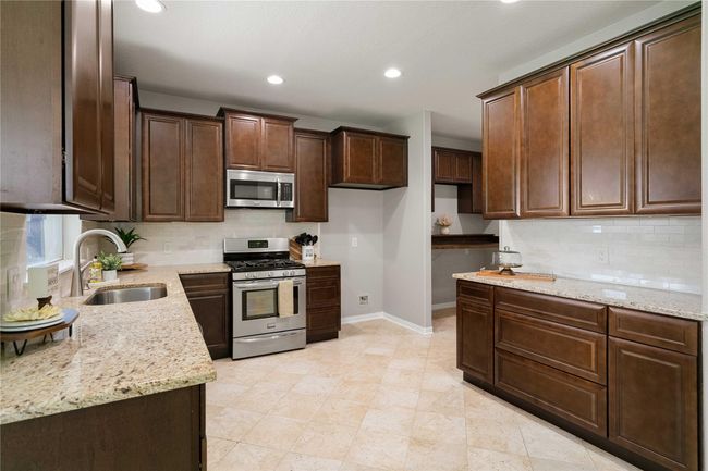 Updated 42" cabinets and soft close drawers, tile backsplash, granite countertops and LED lighting. | Image 15