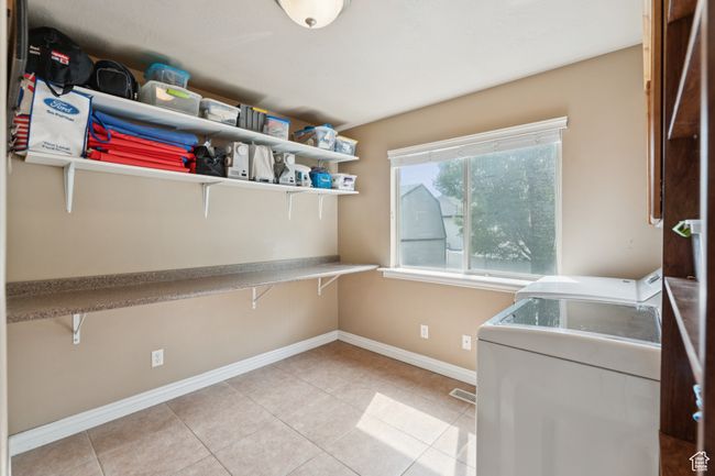 Laundry area featuring baseboards, light tile patterned floors, and separate washer and dryer | Image 19