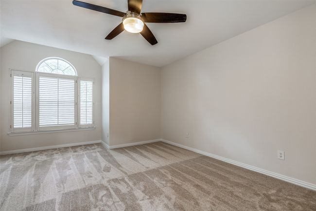 Carpeted empty room featuring ceiling fan, vaulted ceiling, and baseboards | Image 17