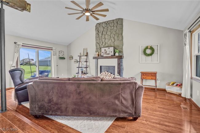 Living room featuring ceiling fan, visible vents, vaulted ceiling, baseboards, and wood finished floors | Image 13
