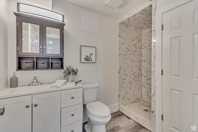 Bathroom featuring vanity, toilet, wood finished floors, and a stall shower | Image 21