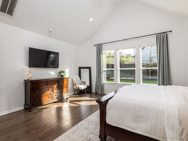 Bedroom with high vaulted ceiling, visible vents, recessed lighting, wood-type flooring, and baseboards | Image 9