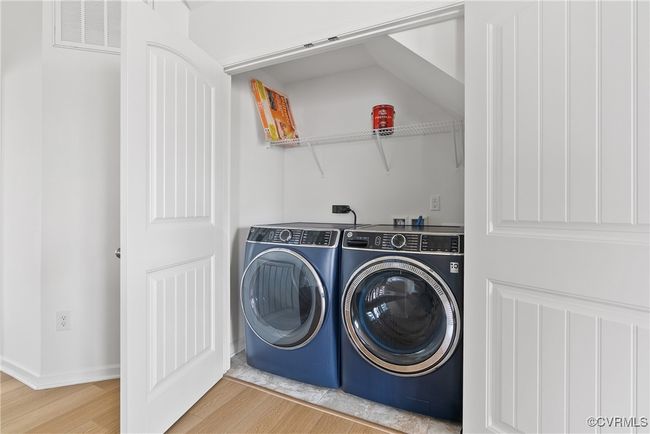 Washroom with visible vents, laundry area, wood finished floors, washer and dryer, and baseboards | Image 15