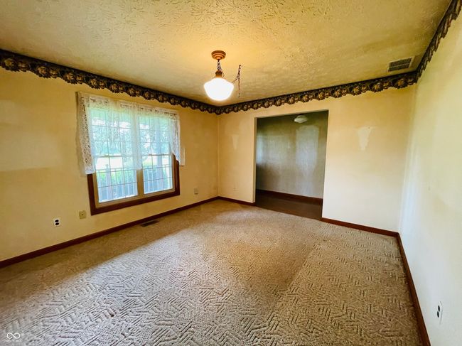 carpeted spare room featuring a textured ceiling and baseboards | Image 11