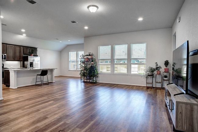 Living room featuring vaulted ceiling, wood finished floors, baseboards, visible vents, and recessed lighting | Image 8
