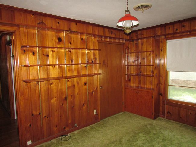 Bedroom with Knotty pine paneling - wood floors under carpet | Image 10