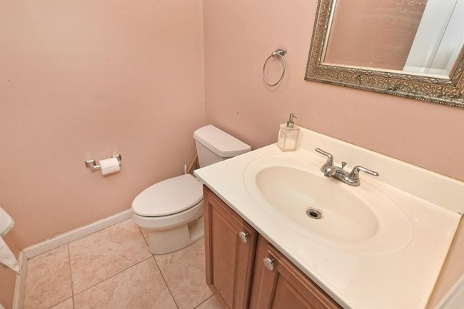 Bathroom with baseboards, toilet, tile patterned floors, and vanity | Image 10