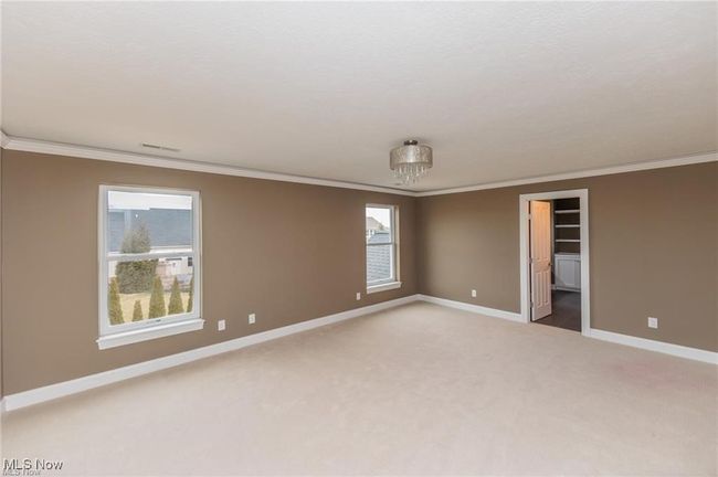 Spare room featuring baseboards, ornamental molding, and light carpet | Image 9