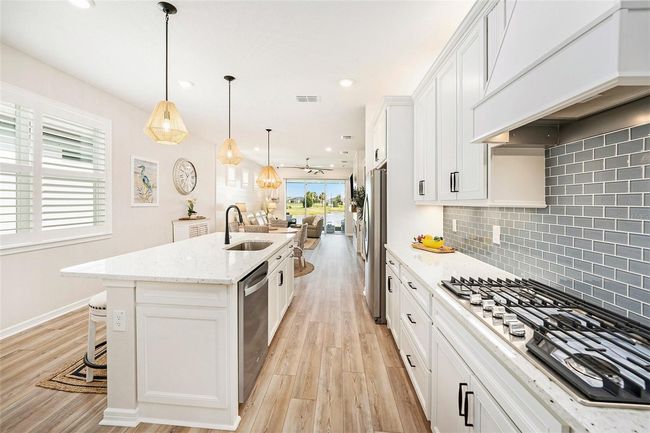 Natural gas range, custom range hood, high ceilings, and luxury vinyl plank flooring. And don't forget the pantry! | Image 8