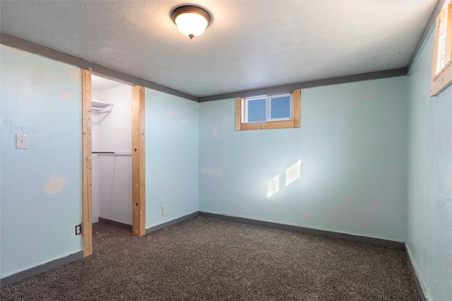 Bright lower-level room with multiple windows for natural light. | Image 54