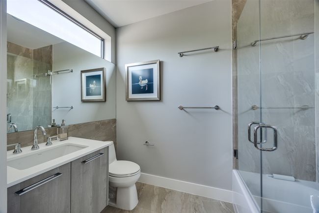 Full bath with vanity, tile walls, marble finish floor, baseboards, and toilet | Image 28