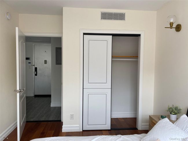 Bedroom with dark wood-type flooring and a closet | Image 11