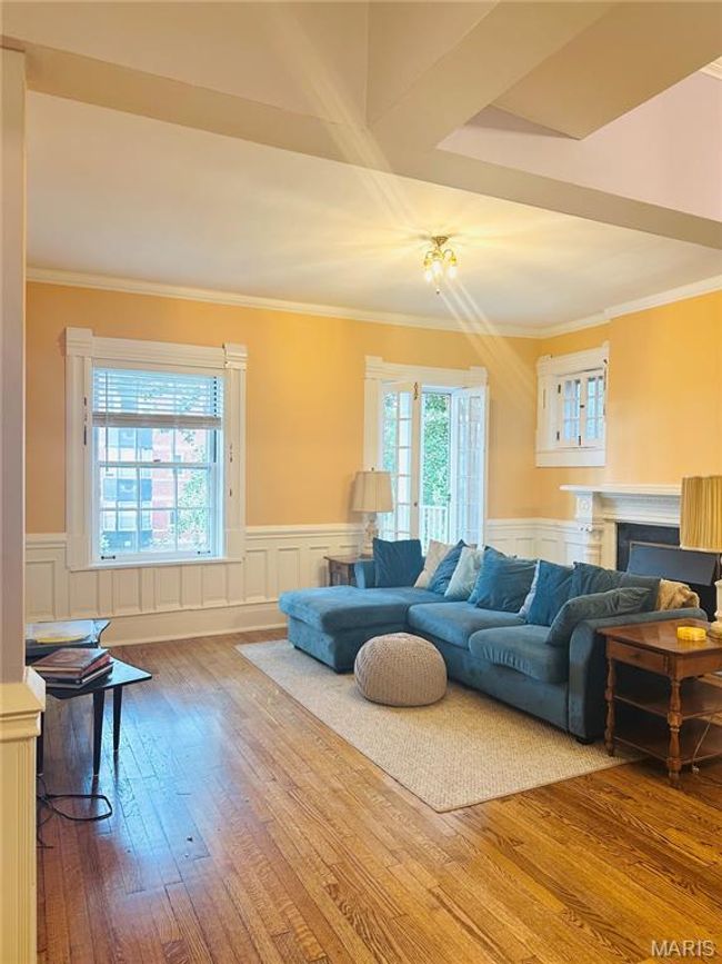 Living area with plenty of natural light, hardwood / wood-style flooring, a fireplace, a decorative wall, and wainscoting | Image 5
