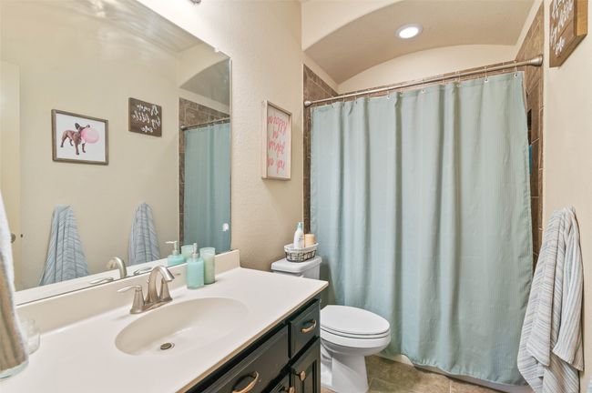 Bathroom with toilet, curtained shower, and vanity | Image 24