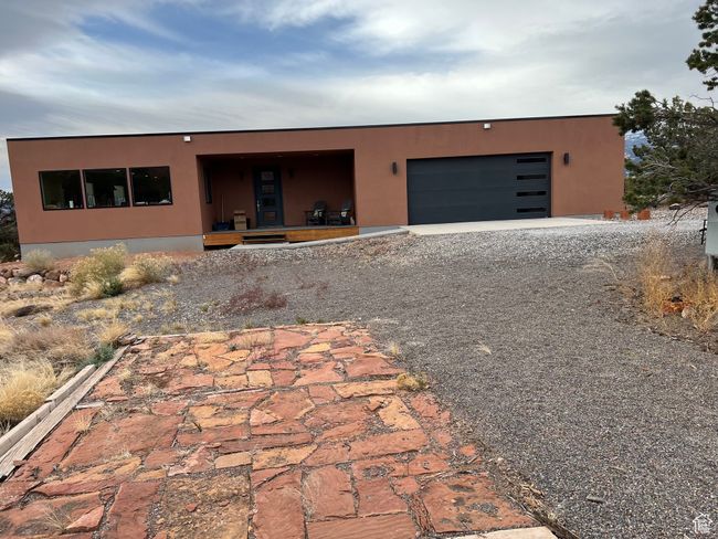 View of front facade with driveway, stucco siding, and an attached garage | Image 45