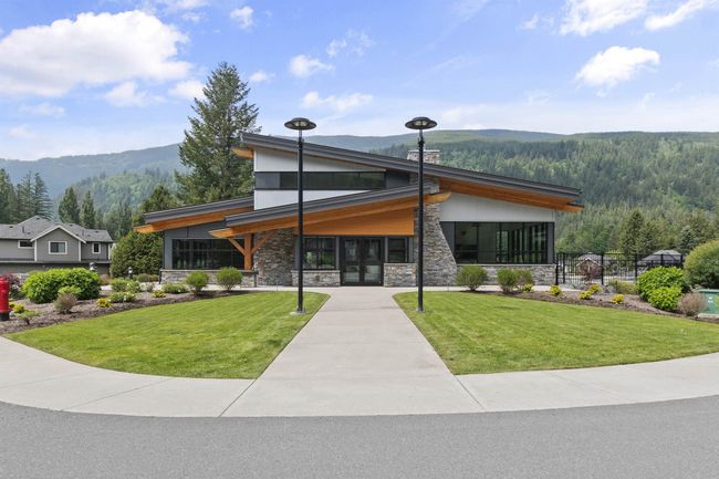 View of front of home with a mountain view, stone siding, a front lawn, and a sunroom | Image 30