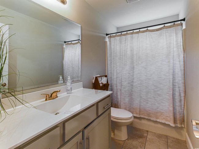 Full bathroom with vanity, toilet, shower / bathtub combination with curtain, and tile patterned flooring | Image 27